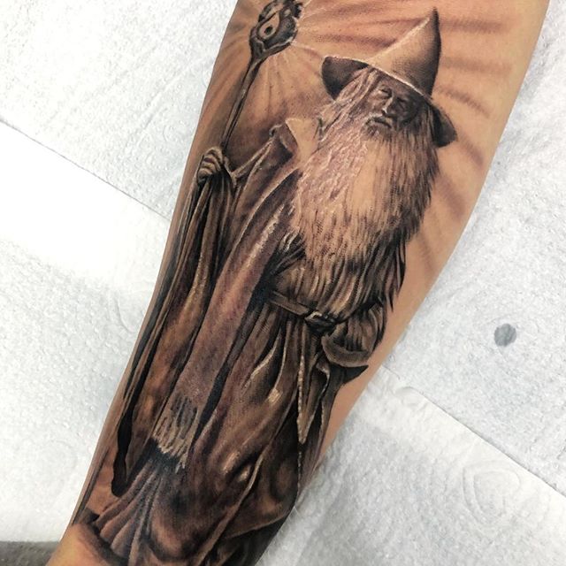 Black tattoo of Gandalf with his stick