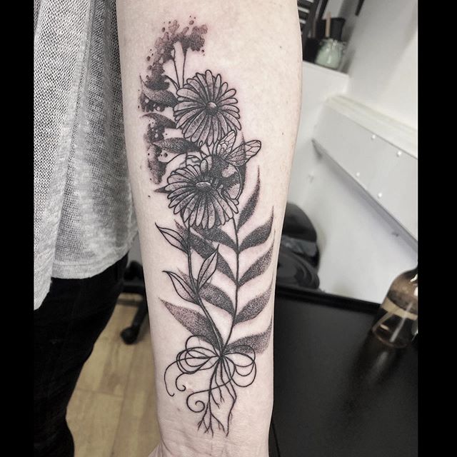 Black tattoo of flowers on the left hand