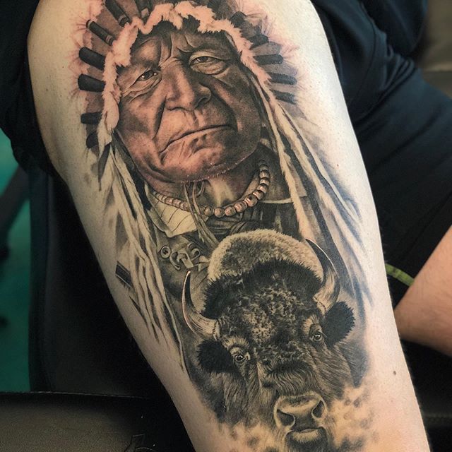 Black and grey tattoo of an Indian warrior with a buffalo on the right leg