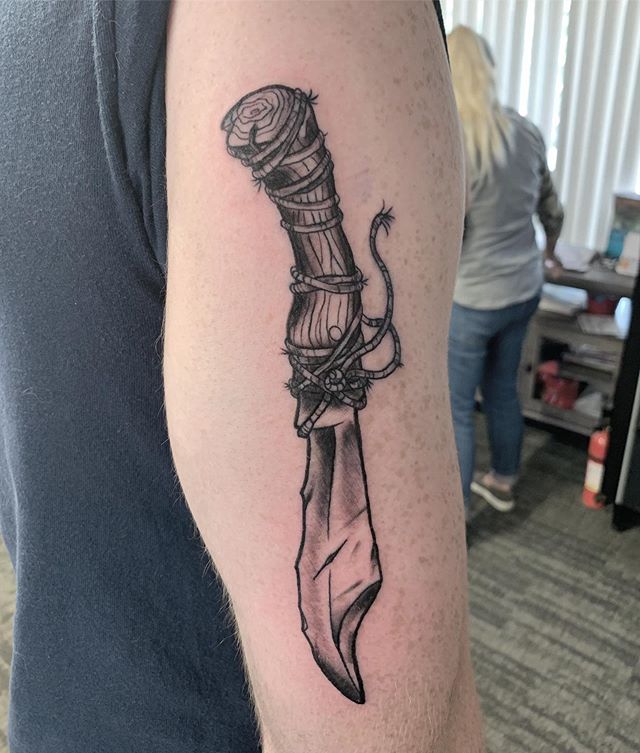 Black and grey tattoo of a dagger on the right hand