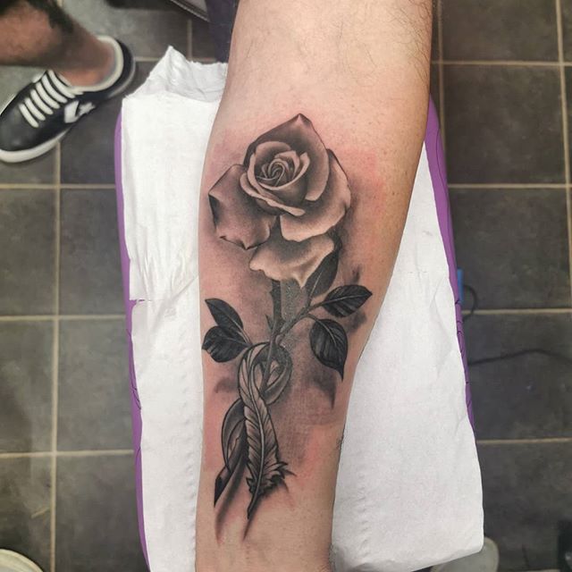 Black and Gray tattoo of a flower on the left calf
