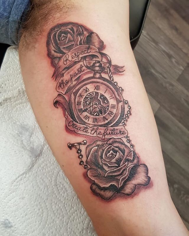 Black and grey tattoo of an old watch with roses and text on the left hand