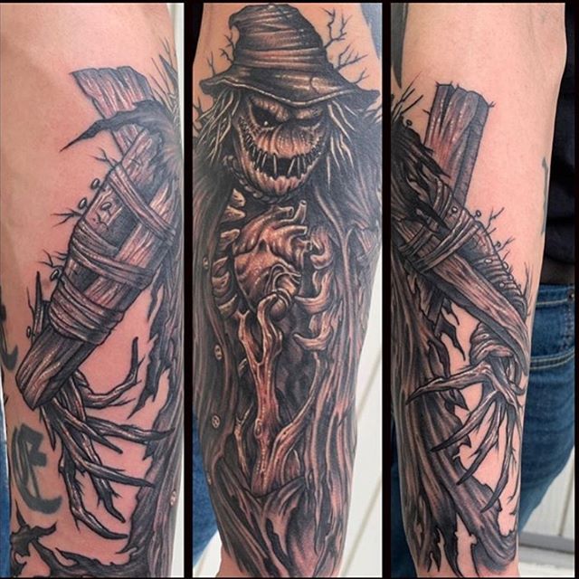 Black and grey tattoo of a creepy scarecrow on the calf
