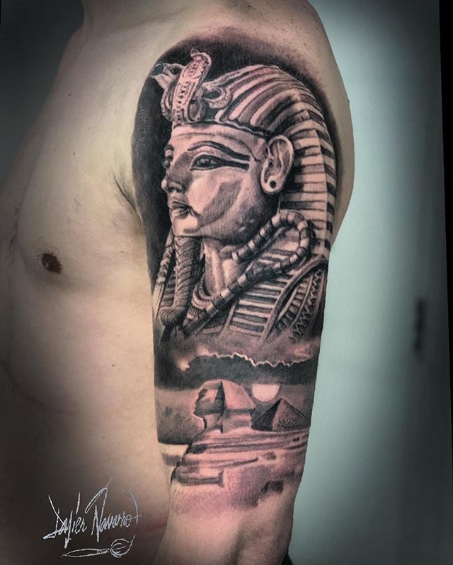 Black and grey tattoo of a Pharaoh's head, the Great Sphinx and a Pyramid on the left hand