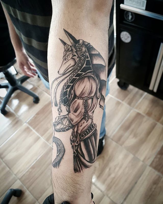 Black and grey tattoo of Anubis on the left hand