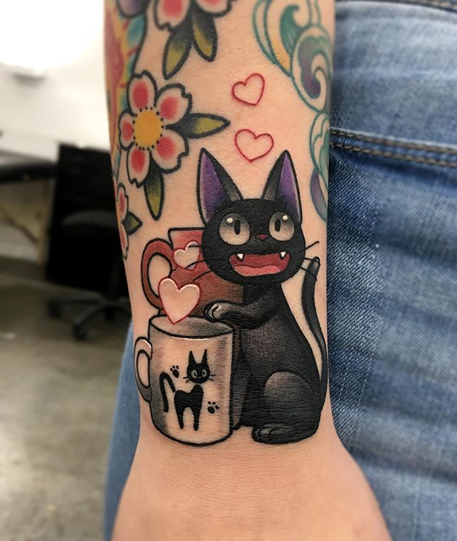Cartoon tattoo of Jiji the cat with a cup on the right hand