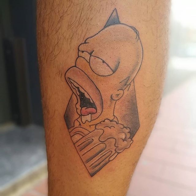 Cartoon tattoo of drunk Homer Simpson on a calf