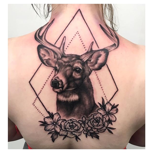Dot work tattoo of a deer's head with flowers on the back