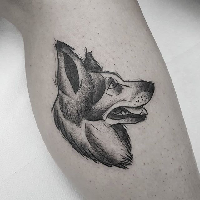 Dot work tattoo of a dog's head on the calf
