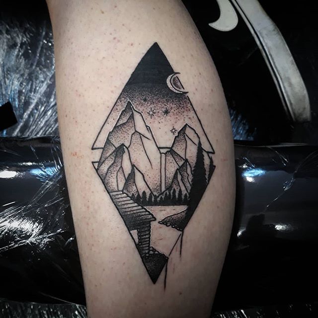 Dot work tattoo of mountains on the calf