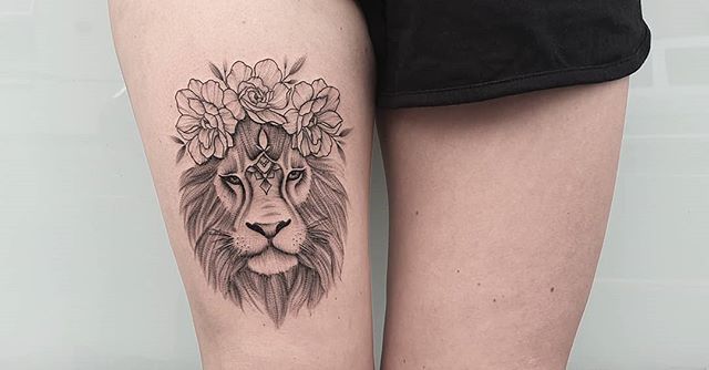 Dot work tattoo of a lion with flowers on the right leg