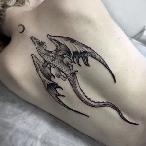 Dot work tattoo of a flying dragon with moon on the back