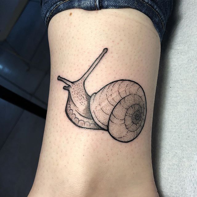 Dot work tattoo of a snail above the ankle