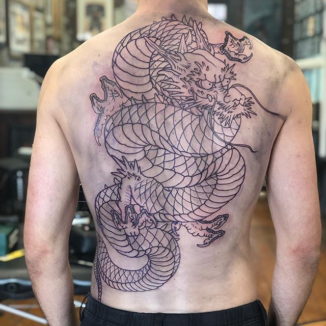 Big rriental tattoo of a dragon on the whole back