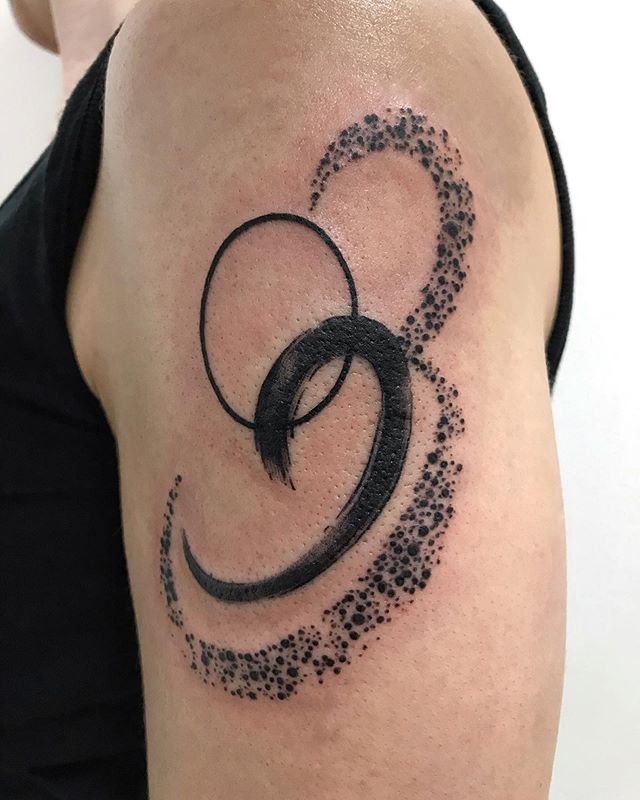 Abstract tattoo of a circle and curves on the left hand