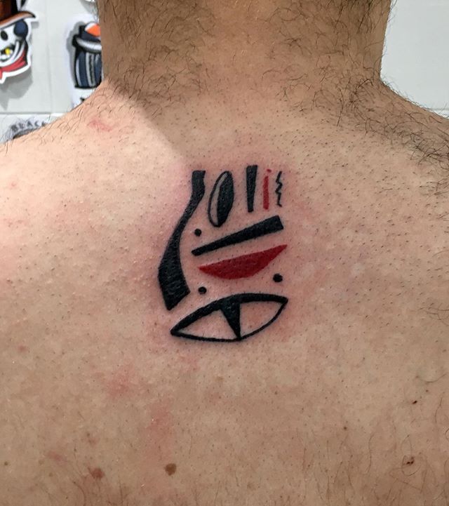 Abstract tattoo of an eye and lines on the back