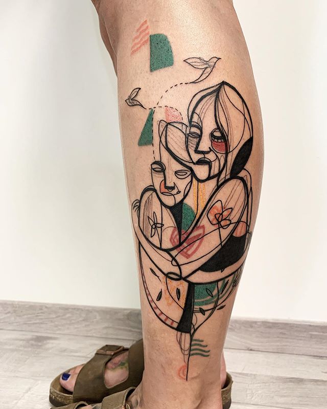 Abstract tattoo of a hugging couple on the left calf