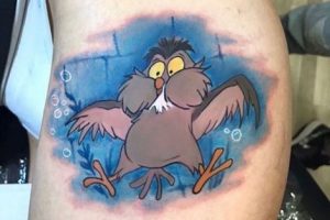 Cartoon tattoo of Archimedes the owl on the left leg