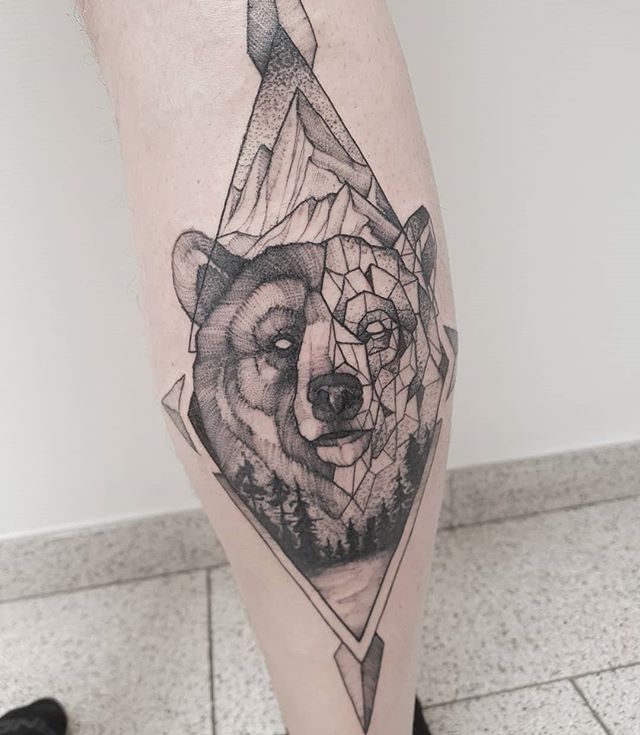 Geometric tattoo of a bear head on the right calf