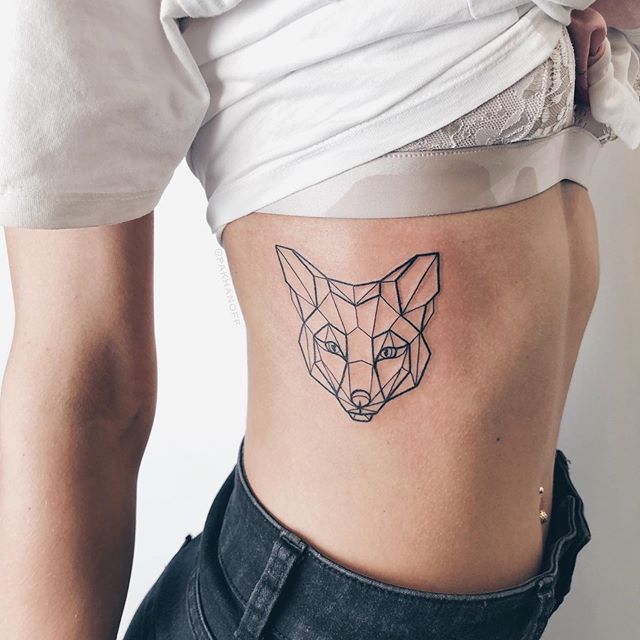 Geometric tattoo of a fox head on the right side of the chest