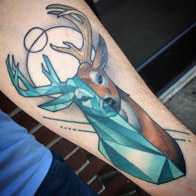 Geometric tattoo of a deer head on the left hand