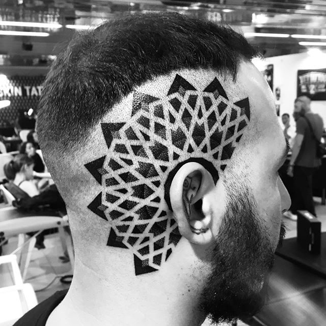 Geometric tattoo of lines and triangles on the right side of a head