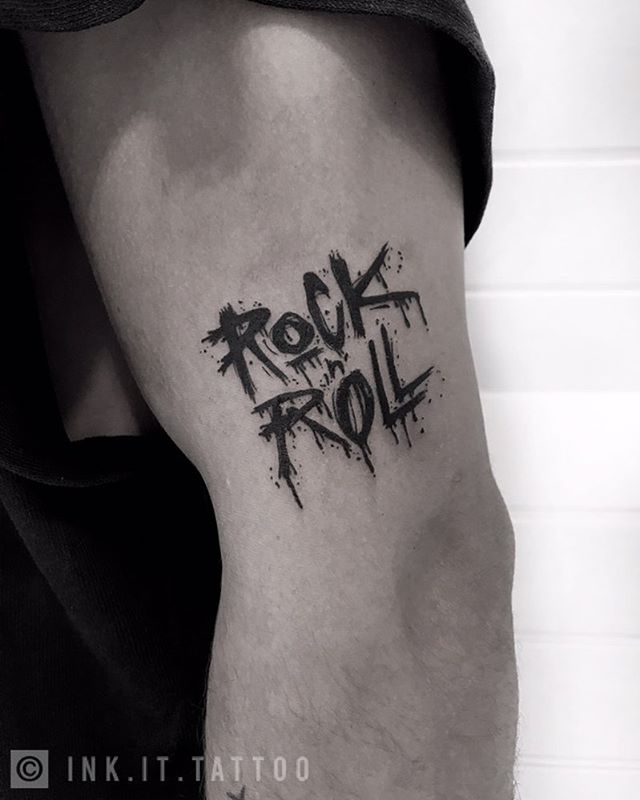 Lettering tattoo of a "rock n' roll" on the left hand