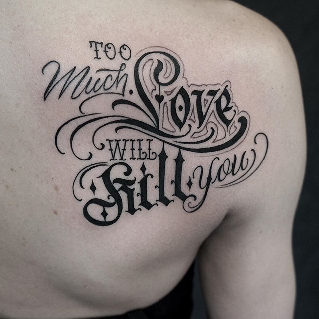 Lettering tattoo of a "too much love will kill you" on the left shoulder