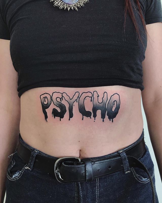 Lettering tattoo of a "psycho" on the chest