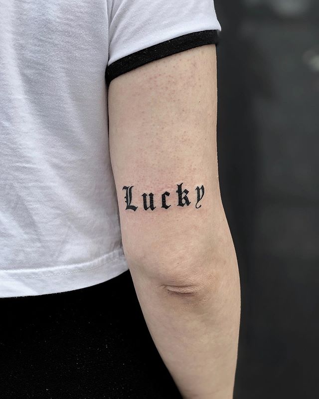Lettering tattoo of a "lucky" on the right hand