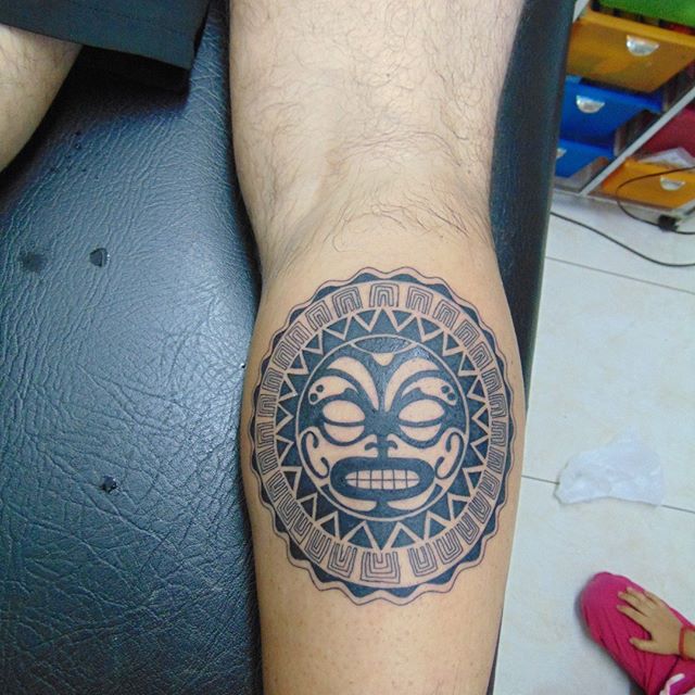 Maori tattoo of a face on the right calf