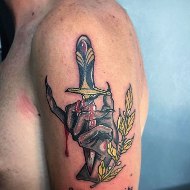 Neotraditional tattoo of a dagger in a hand with blood and a olive branch on the left shoulder
