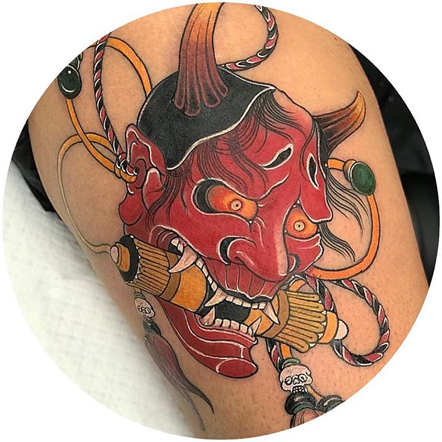 Oriental tattoo of a devil head with a scroll in his mouth