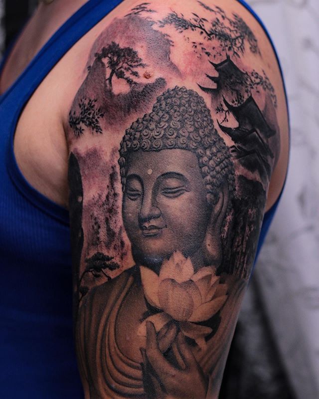 Oriental tattoo of Buddha with a lotus flower on the left arm