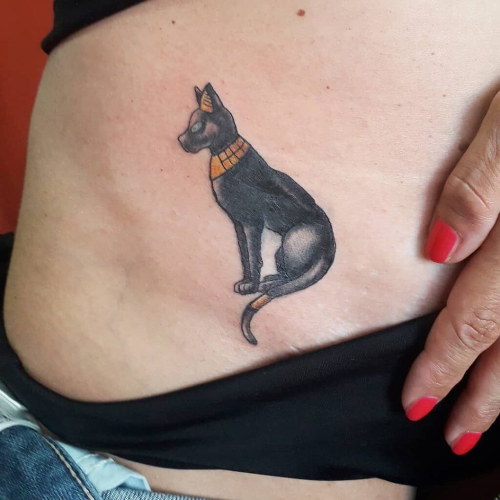 Female tattoo of a black cat on the belly