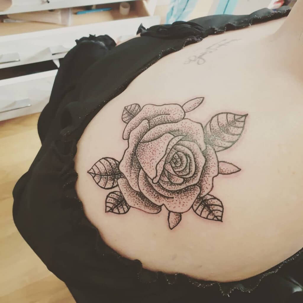Dot work rose tattoo on the right shoulder