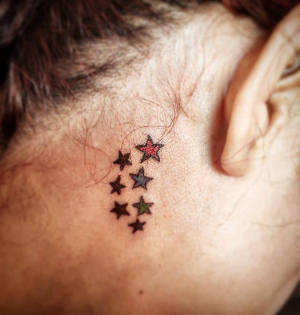 Color Stars tattoo behind right ear