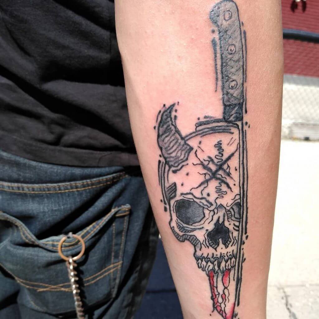 Forearm tattoo of a devils skull with knife