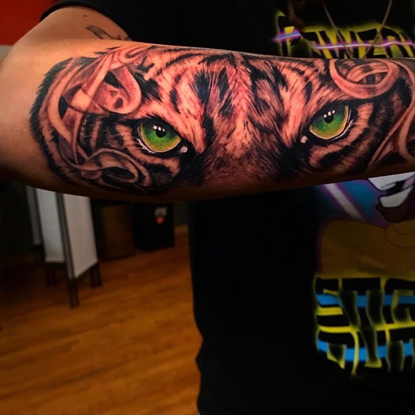 Color Forearm tattoo of a tiger green eyes