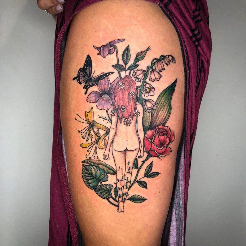 Color Female tattoo of a woman, a butterfly and flowers on the left thigh