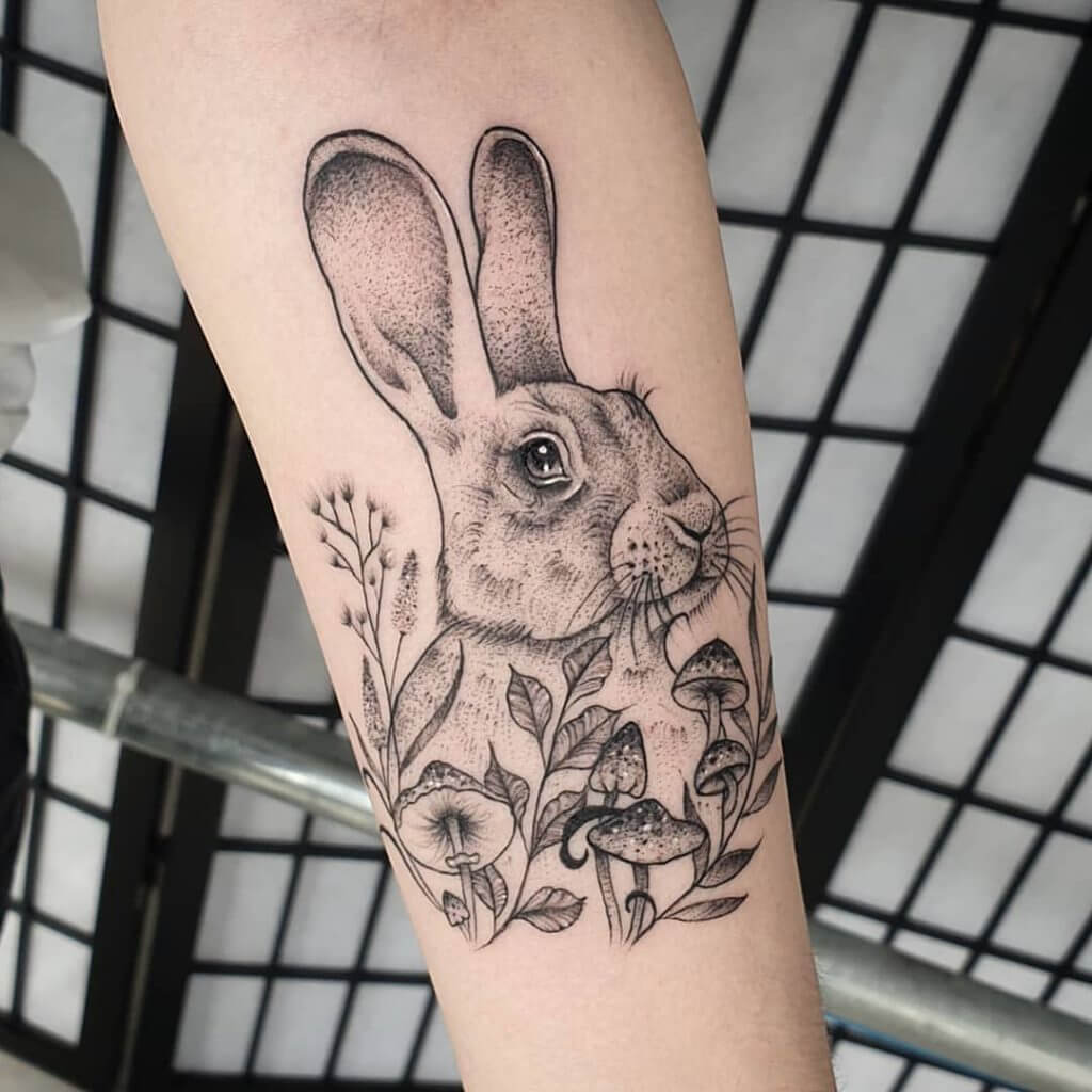 Black Bunny tattoo with mushrooms on the left forearm