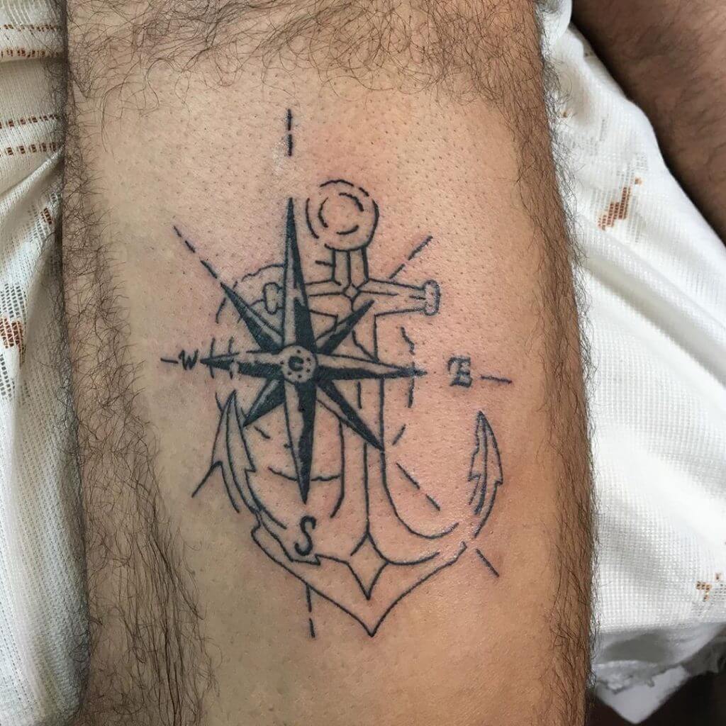 Black Compass tattoo with an anchor on the left calf