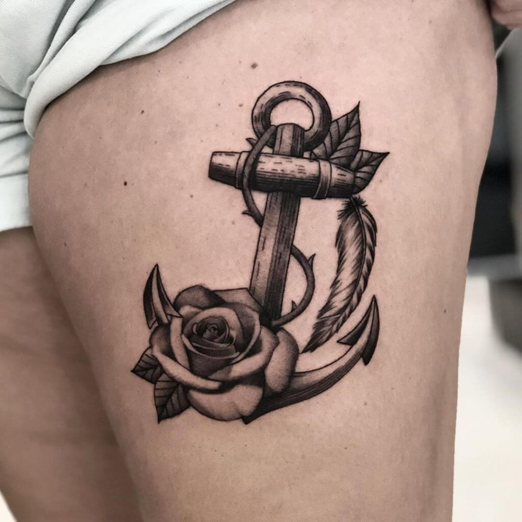 Black Anchor tattoo with a feather and a rose on the left thigh