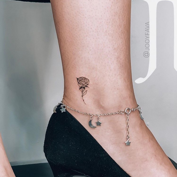 Small Black tattoo of a rose on the left foot