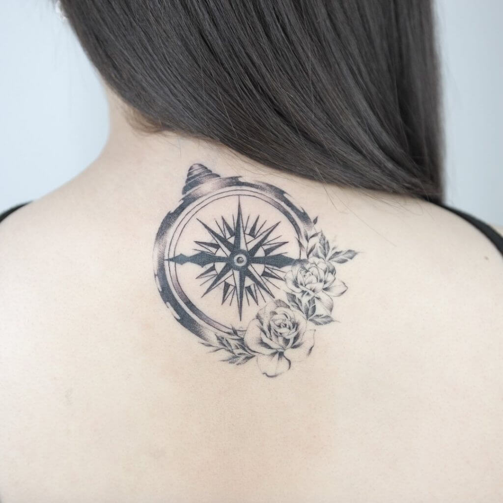 Black Compass tattoo with roses on the back