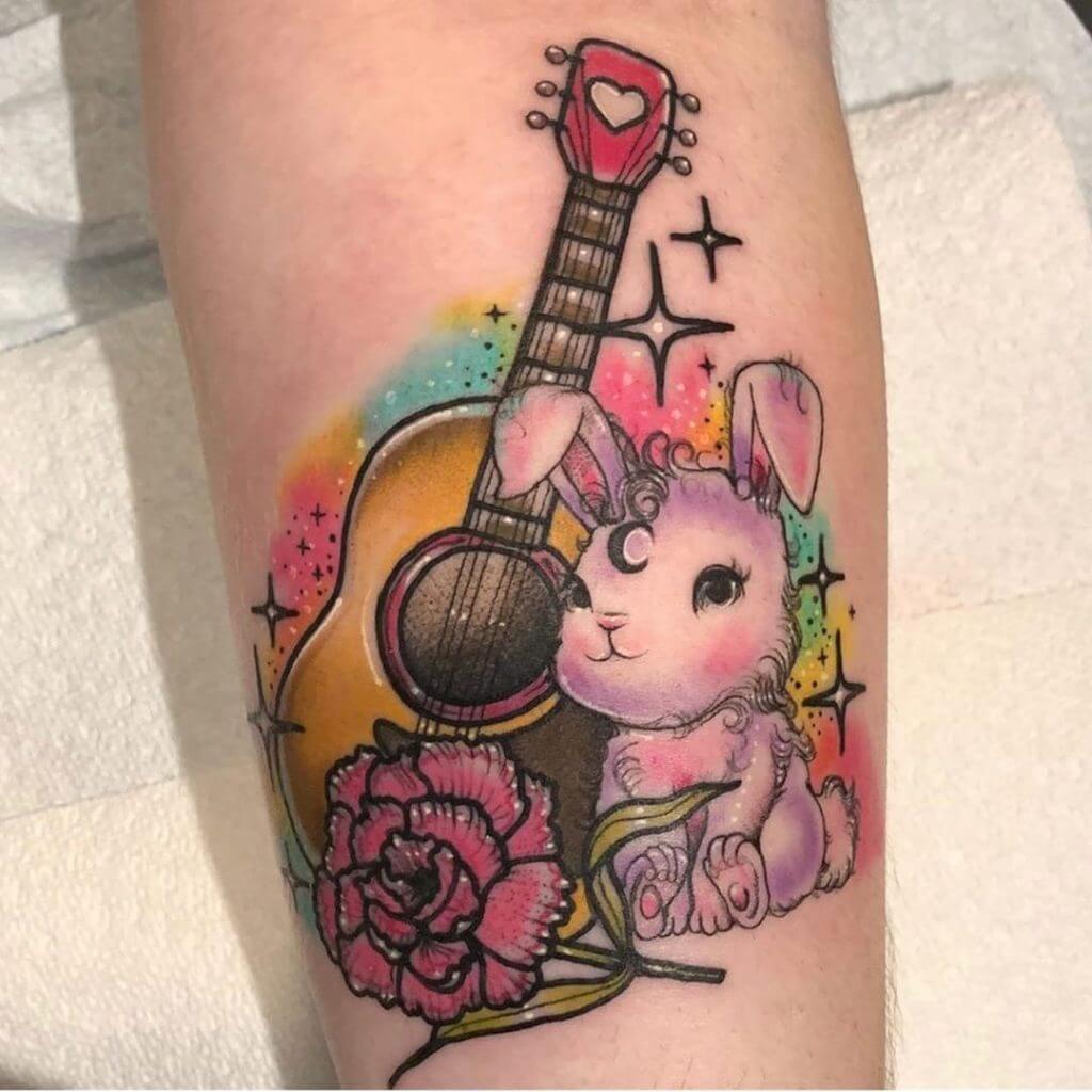 Color Bunny tattoo with a flowers and the guitar on the forearm