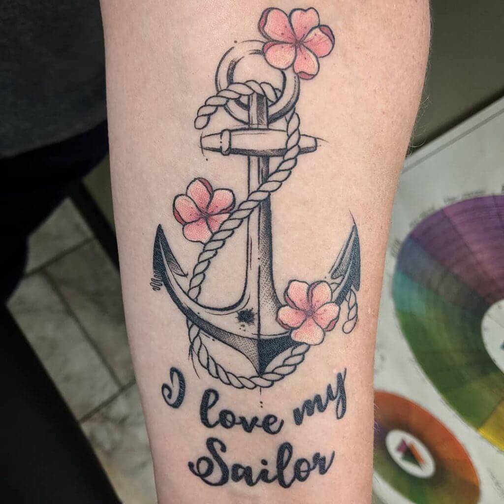 Anchor and pink flowers tattoo on the calf