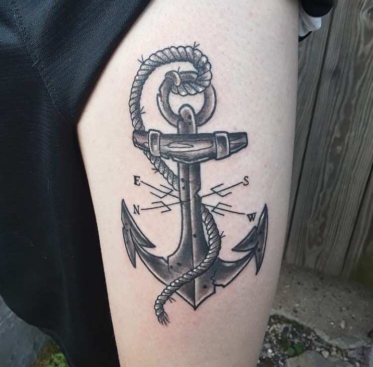 Black Anchor tattoo with a compass on the left thigh