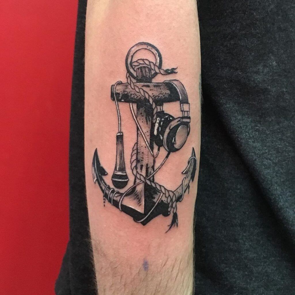 Black Anchor tattoo with a microphone and headphones on the right arm