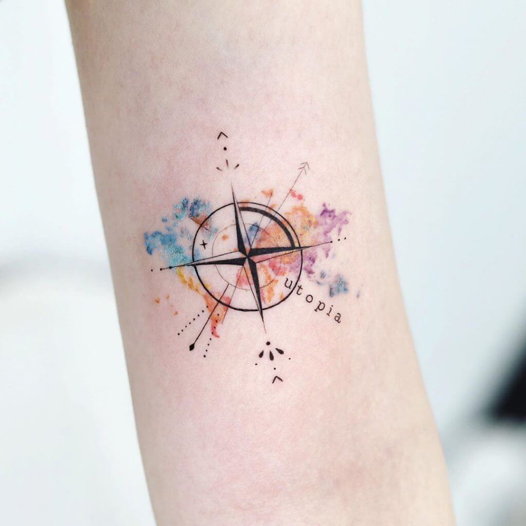 Watercolor Compass tattoo with the world map on forearm